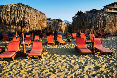 Chairs on beach against sky