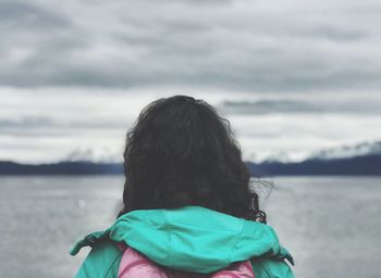 Rear view of woman looking at sea against sky