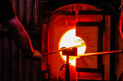 Close-up of man working on metal structure at night