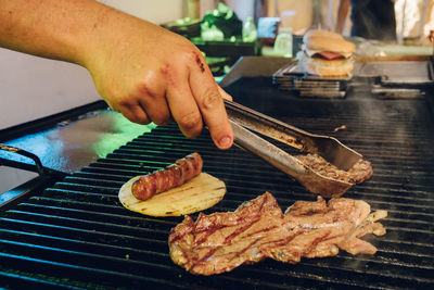 Close-up of man preparing food on barbecue grill