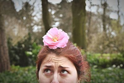 Portrait of young woman with pink flower