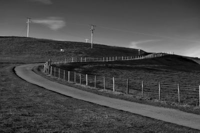 Road by landscape against sky