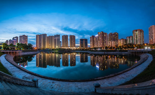 Reflection of illuminated buildings in pond at night