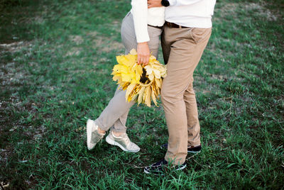 Low section of woman standing on grassy field