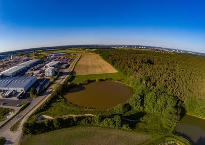 High angle view of green landscape against blue sky