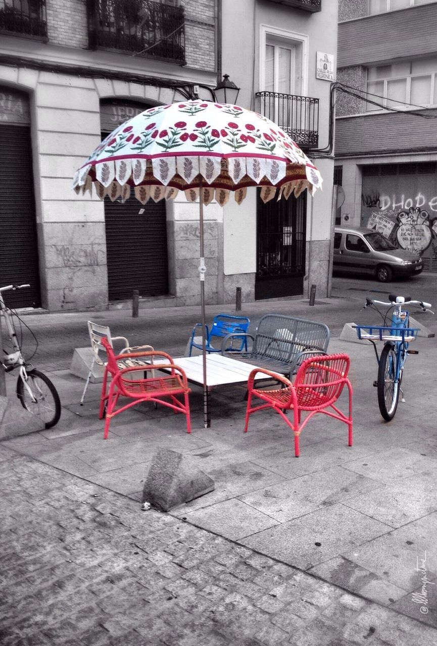 bicycle, building exterior, built structure, architecture, transportation, hanging, street, stationary, parked, land vehicle, mode of transport, day, parking, outdoors, wall - building feature, no people, sidewalk, city, sunlight, house