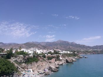 Panoramic view of sea and buildings against blue sky