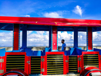 Full length of man standing against red blue sky