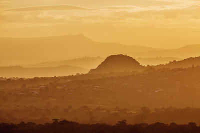 Scenic view of silhouette mountains against orange sky