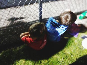 High angle view of cute girl lying on fence