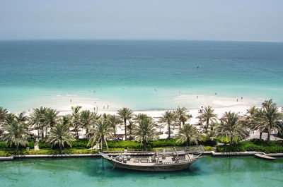 An abandoned boat anchored in a man made lake against the backdrop of arabian sea