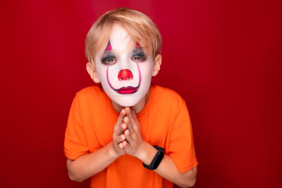 Portrait of boy holding red face