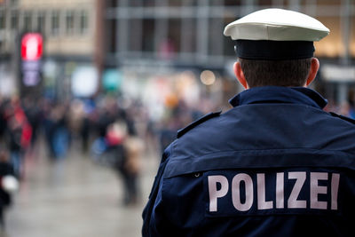 Rear view of traffic cop standing in city