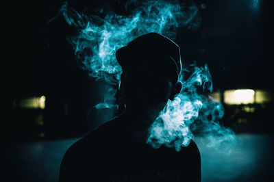 Close-up of man smoking cigarette at night