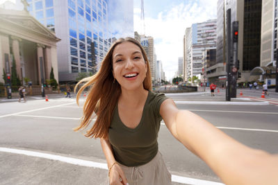 Portrait of young woman standing in city