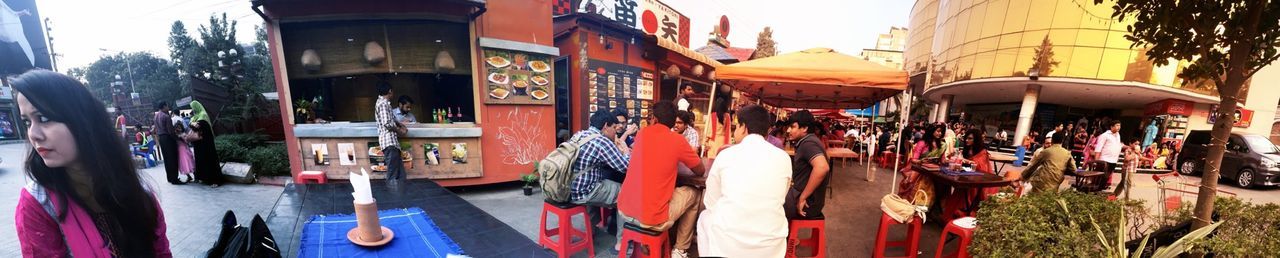 large group of people, person, panoramic, men, building exterior, lifestyles, built structure, architecture, leisure activity, outdoors, day, crowd, street, in a row, sunlight, city life, hanging, retail, incidental people