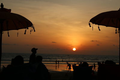 Silhouette people on beach during sunset