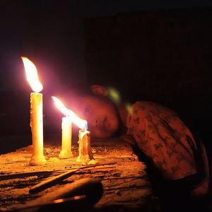 Close-up of lit candles on table