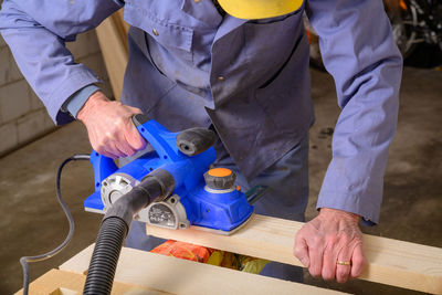 Low angle view of man working on wood