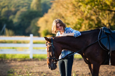 Woman riding horse on field