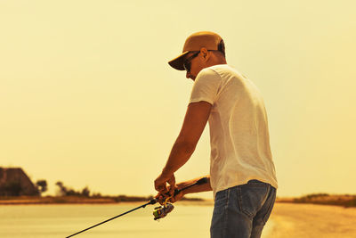 Side view of man standing against clear sky