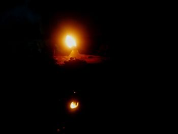 Close-up of illuminated candle against sky at night