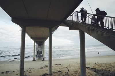 People at beach against sky