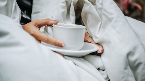 Midsection of man holding coffee cup