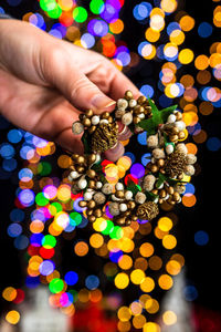 Cropped hand of woman holding christmas decorations