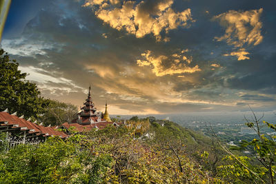 Panoramic view of trees and buildings against sky during sunset