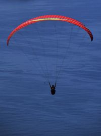 Rear view of person paragliding over sea