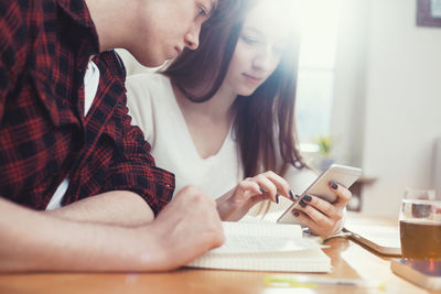 Close-up of young woman using mobile phone at home