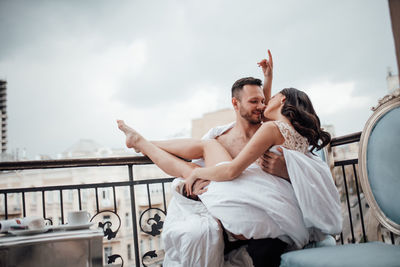Happy couple kissing against sky