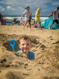 High angle view of people walking at beach. makes child digging in sand on english beach. 