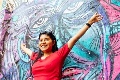 Smiling young woman with arms outstretched