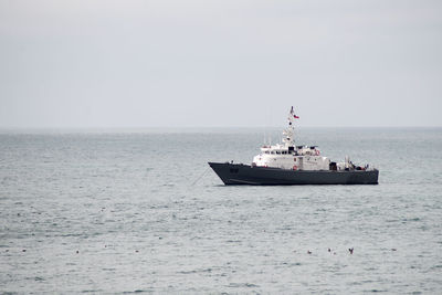 Ship sailing on sea against clear sky