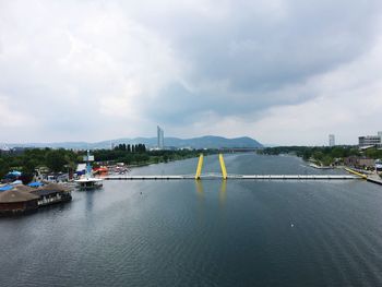 Bridge over river in city against sky