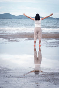 Rear view of woman standing on beach