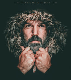 Portrait of man wearing mask against black background
