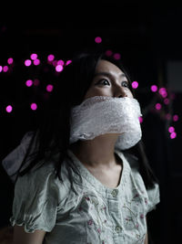 Portrait of beautiful young woman standing at night