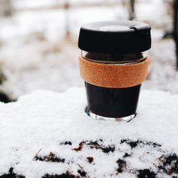 Close-up of coffee cup on snow covered field