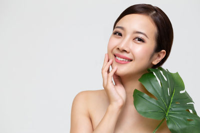 Portrait of a smiling young woman over white background