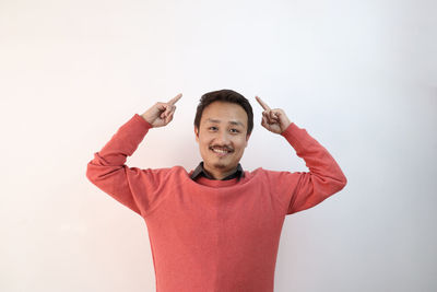 Portrait of smiling man standing against white background