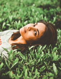 Portrait of young woman lying on plants