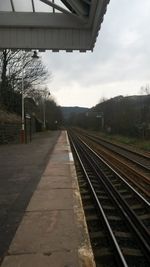 Railroad track against cloudy sky