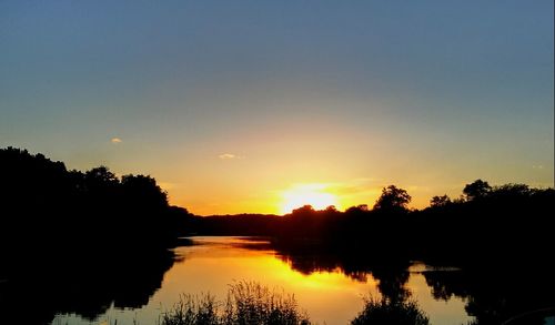 Scenic view of lake against orange sky