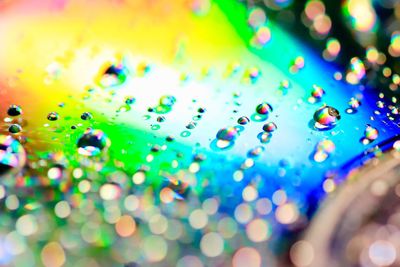 Close-up of water drops on multi colored background