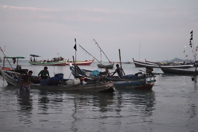 Boats moored in sea against sky