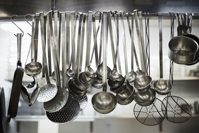 Utensils on metal rack in commercial kitchen