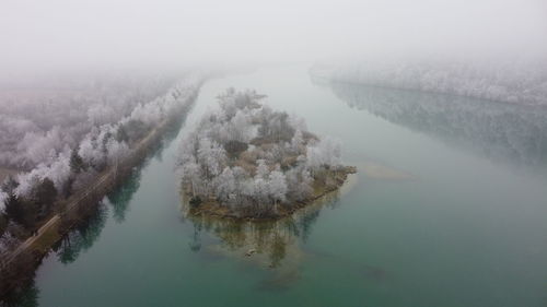 High angle view of lake by trees during foggy weather